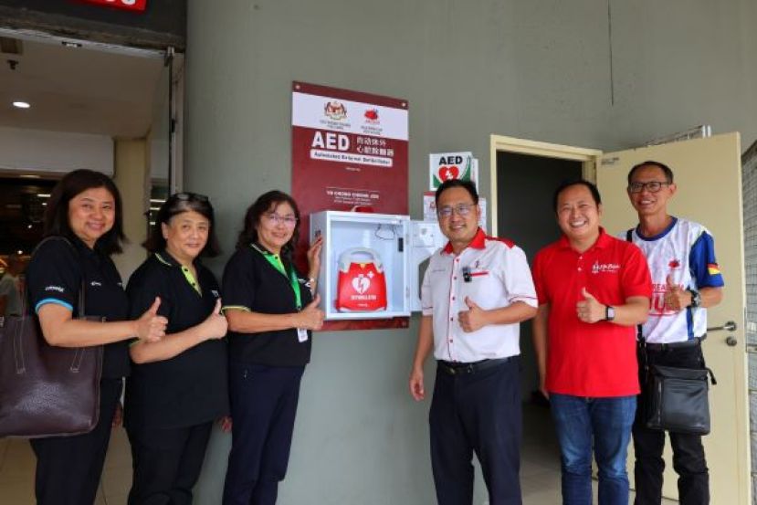 实旦宾区国会议员兼浮罗岸区州议员张健仁（右3）主持AED设备移交及推展礼后，与永升百货公司有限公司管理层及古晋佳果康乐协会代表合影。左起为高级行政经理谢仙施、BDC分行门店高级经理刘慧玲及高级营运经理刘美莲；右起为古晋佳果康乐协会副主席陈家钱及张健仁特别助理兼砂商用车辆注册局主席江峰年。