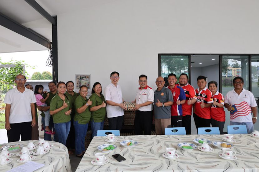 张健仁（右7）在众人的陪同下，移交生鸡蛋予神父欧庆伟（前左5）。右2至5分别是古晋佳果康乐协会委员吴瑞芳、李和达、秘书陈祥声及张健仁特别助理沈杰龙。