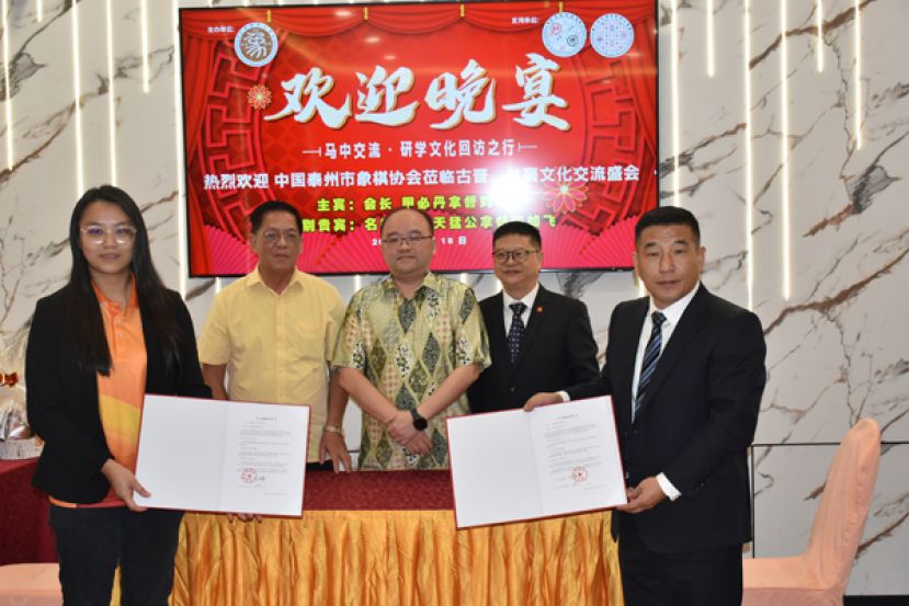 古晋象棋公会与中国泰州市象棋协会签订友好协议后合影。左起为古晋象棋公会主席余欣如，名誉会长陈如飞，会长甲必丹拿督刘思乐，泰州市体育总会理事及泰州市象棋协会文化顾问李达璟及中国泰州市象棋协会会长刘锦华。