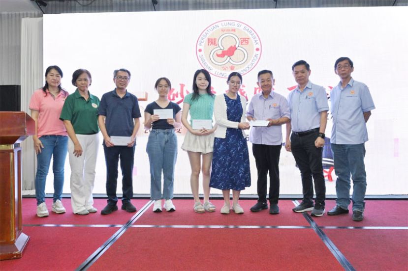 荣获华文科恃优学子或代领奖励金的家长与砂陇西公会主要领导合影。右―起为秘书李仁赵、会长彭囯良、署理会长李开生。