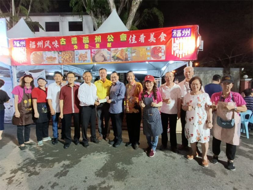 哥打圣淘沙区州议员叶耀星（左六）与砂人联党中央副主席薛华东（左四）见证斯木省华总会长兼成邦江中华总商会会长拿督吴标生（右七）移交捐款古晋福州公会会长拿督余志豪（左五），妇女组主任主任刘碧云（左五）、署理会长拿督王长福（左六）共同合影。