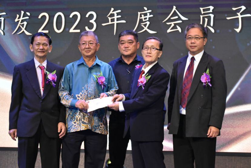 马新咖啡茶业联合总会会长黄守群（左二）在砂拉越咖啡酒餐商联合会主席许凤容（中）的见证下，移交捐款给古晋咖啡酒餐商公会，并由该会财政林观桂（右二）接收。左和右为古晋咖啡酒餐商公会主席张业秋及筹委会主席甲必丹陈贻贤。