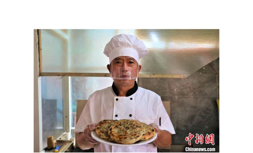 李金柱把烙好的煊饼端上餐桌。