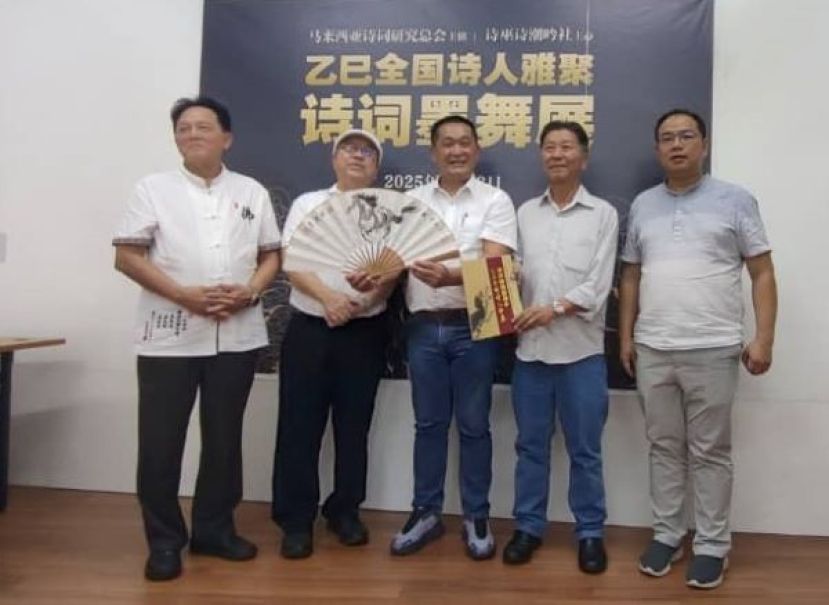 乙巳年全国诗人雅集筹委会主席许庆喜（左二）以及马来西亚诗词研究总会主席杨锦明（右二）赠送纪念品予主宾施志豪时摄。右为马来西亚诗词研究总会秘书长薛君毅；左为诗巫诗潮吟社社长黄政仁。