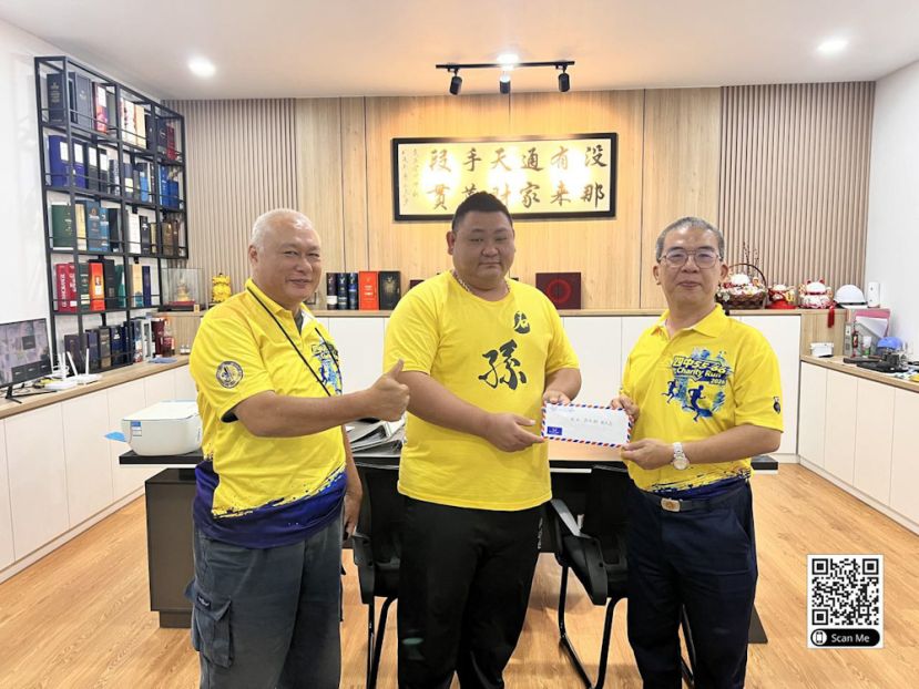 筹委会主席杨力竞移交赞助信函给林伟彬校友，左站着林绍芝。