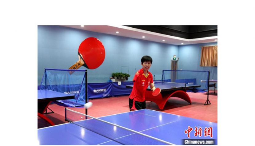 刘旭正在练习打乒乓球。