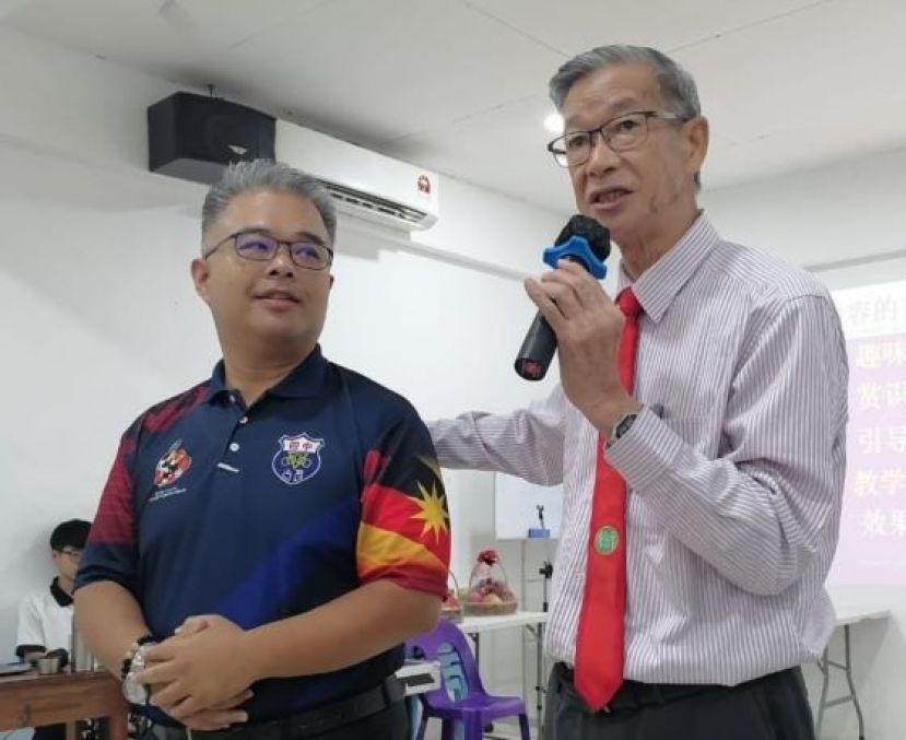 曾桂安（右）在四中主讲赏识教育时与四中校长官晨阳互动。