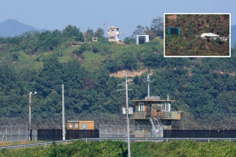 从韩国京畿道坡州向军事分界线望去，可以看到山坡上悬挂朝鲜国旗的军事哨所与扩音器。