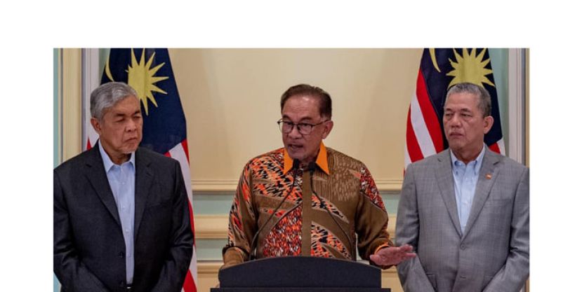 首相安华(中)在阿末扎希(左)和法迪拉(右)陪同下，召开新闻发布会。